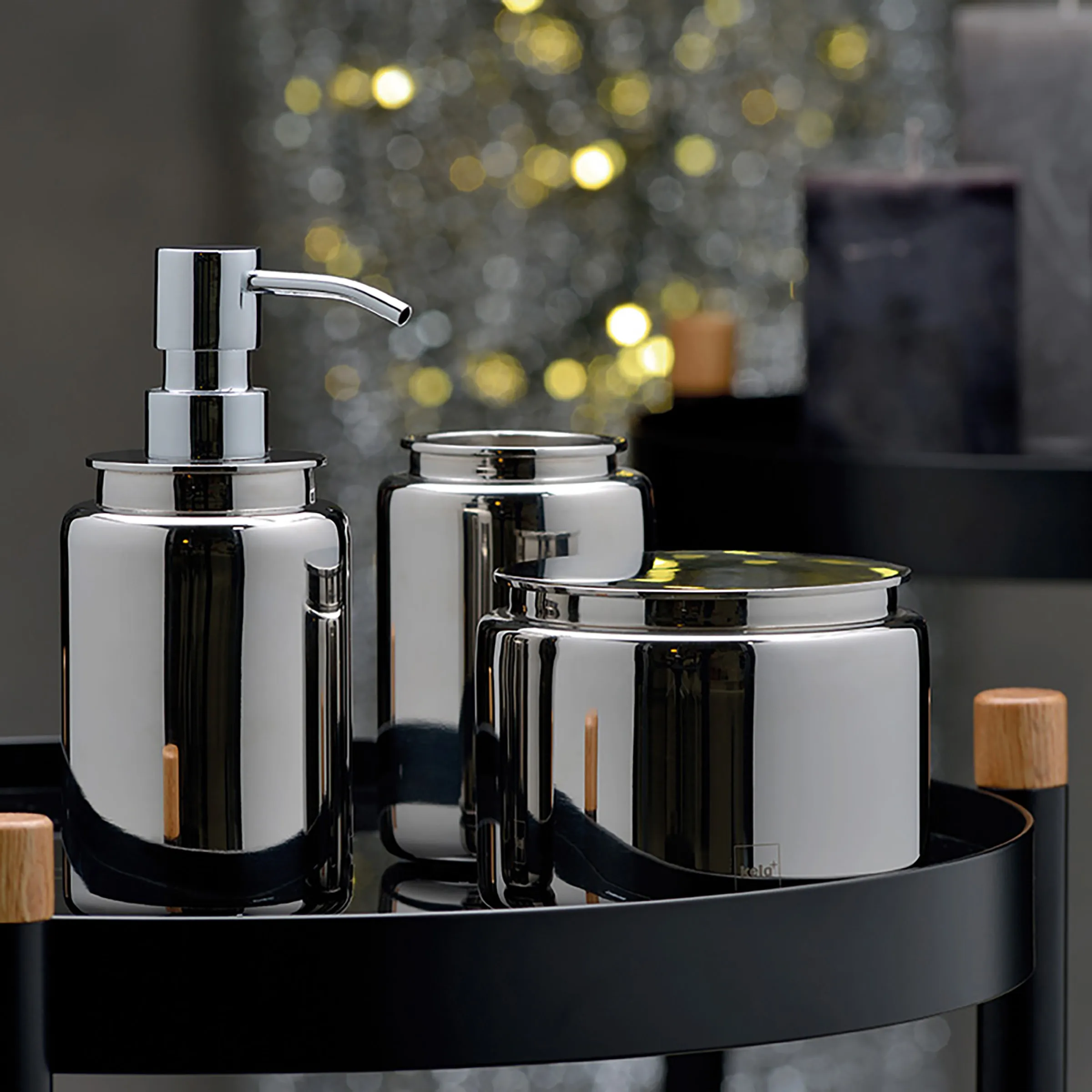 Badezimmer Accessoires Set verchromt - Seifenspender und Aufbewahrungsdosen Modernes Badezimmer-Set mit verchromtem Seifenspender und Aufbewahrungsdosen auf schwarzem Tablett