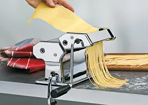 Nudelmaschine Edelstahl - Frische Pasta selber machen Nudelmaschine aus Edelstahl produziert frische gelbe Pasta, Hand füttert Teig ein