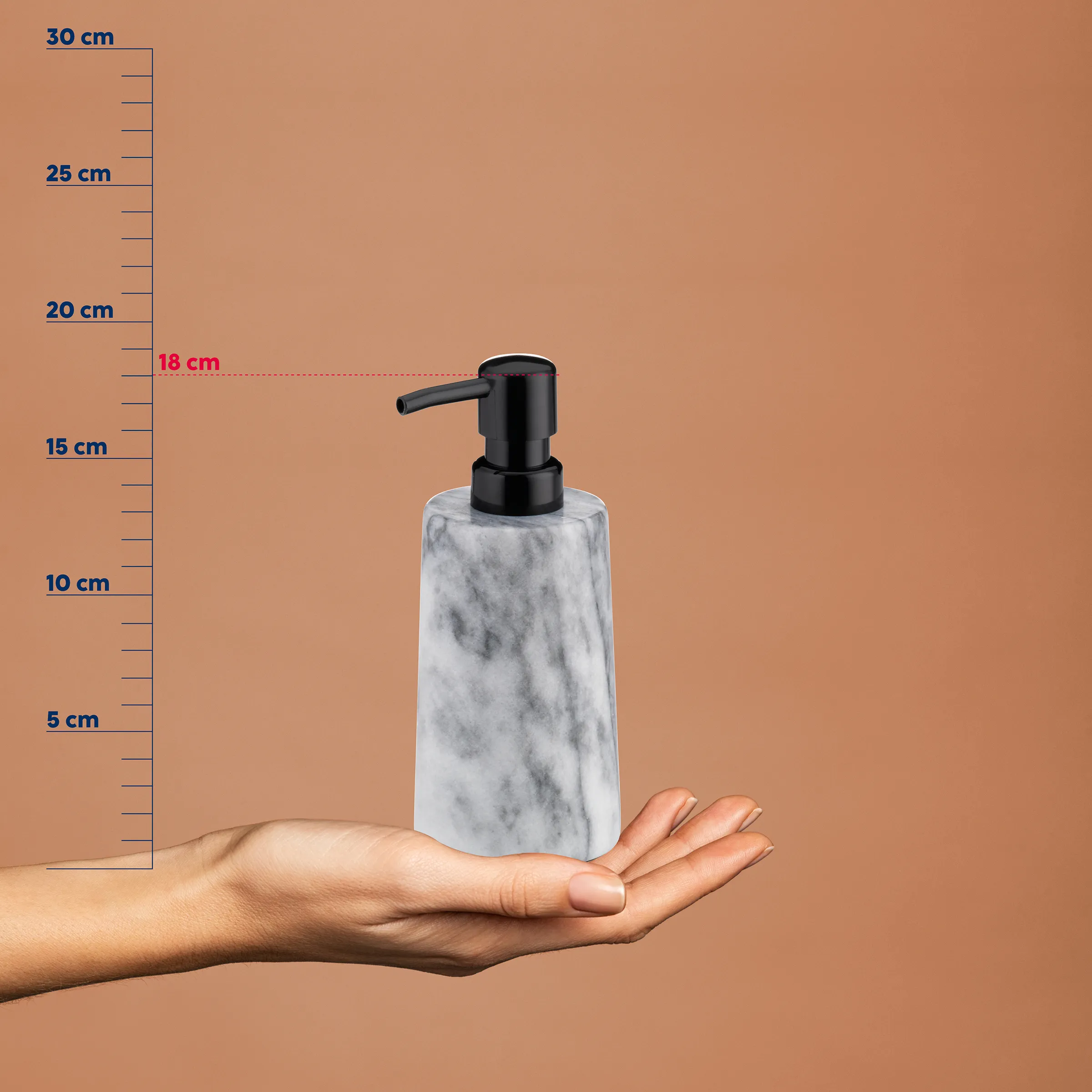 Marmor-Seifenspender mit schwarzem Pumpenkopf in der Hand, neben Messskala bis 30 cm