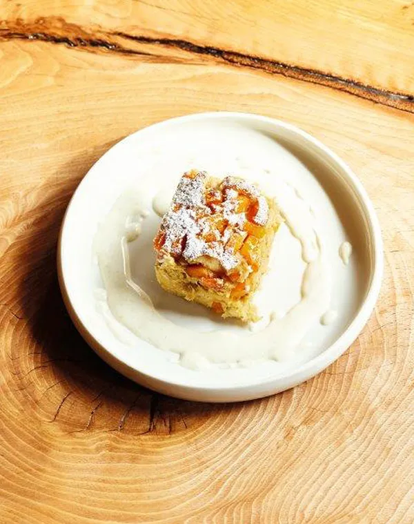 Apfelkuchen mit Vanillesoße - süßes Dessert Dessertteller mit Apfelkuchen-Stück, Puderzucker und Vanillesoße auf Holztisch