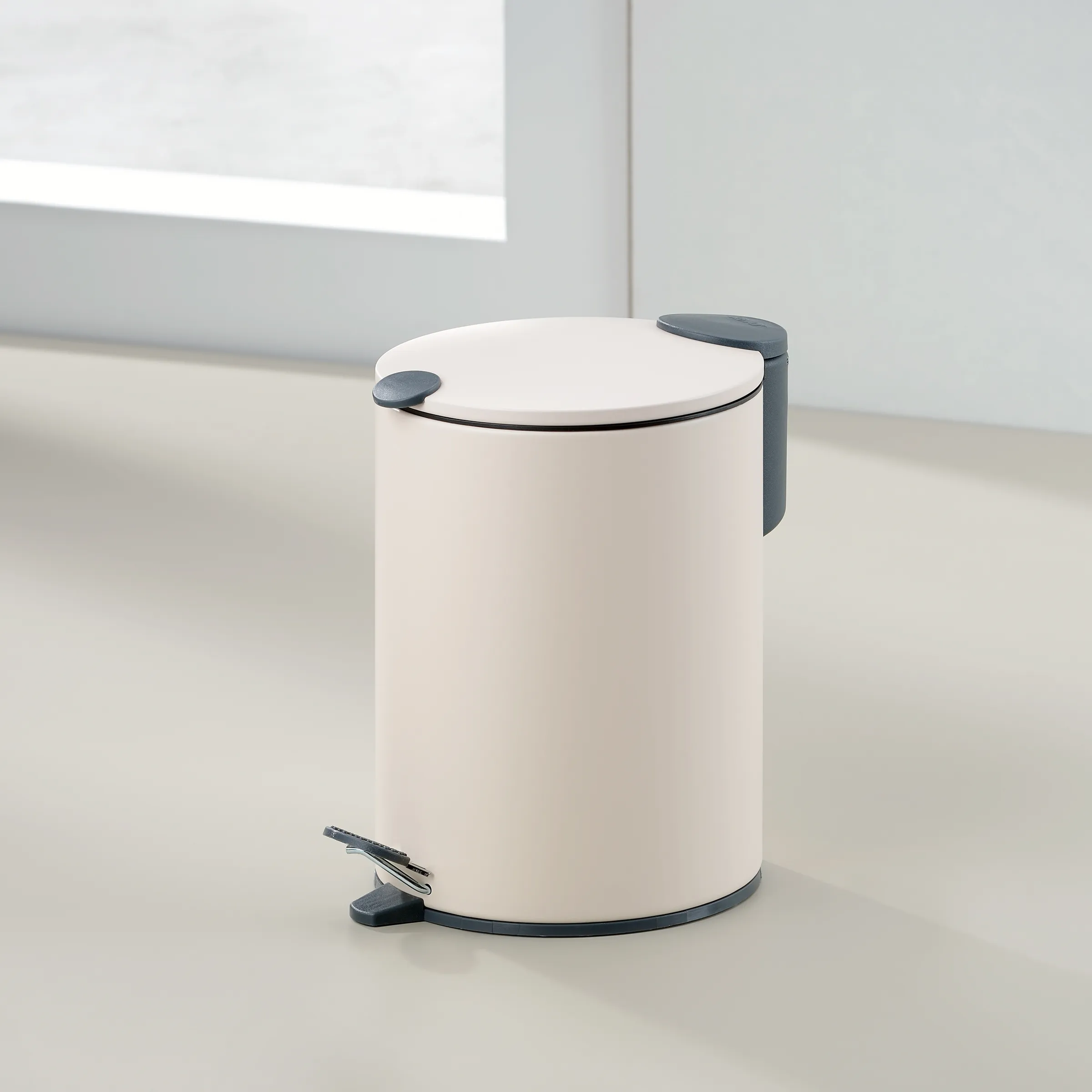Weißer Treteimer mit Pedal - Moderner Abfalleimer für Badezimmer und Küche Weißer Treteimer mit grauem Pedal und Griff in minimalistischem Design auf hellem Untergrund