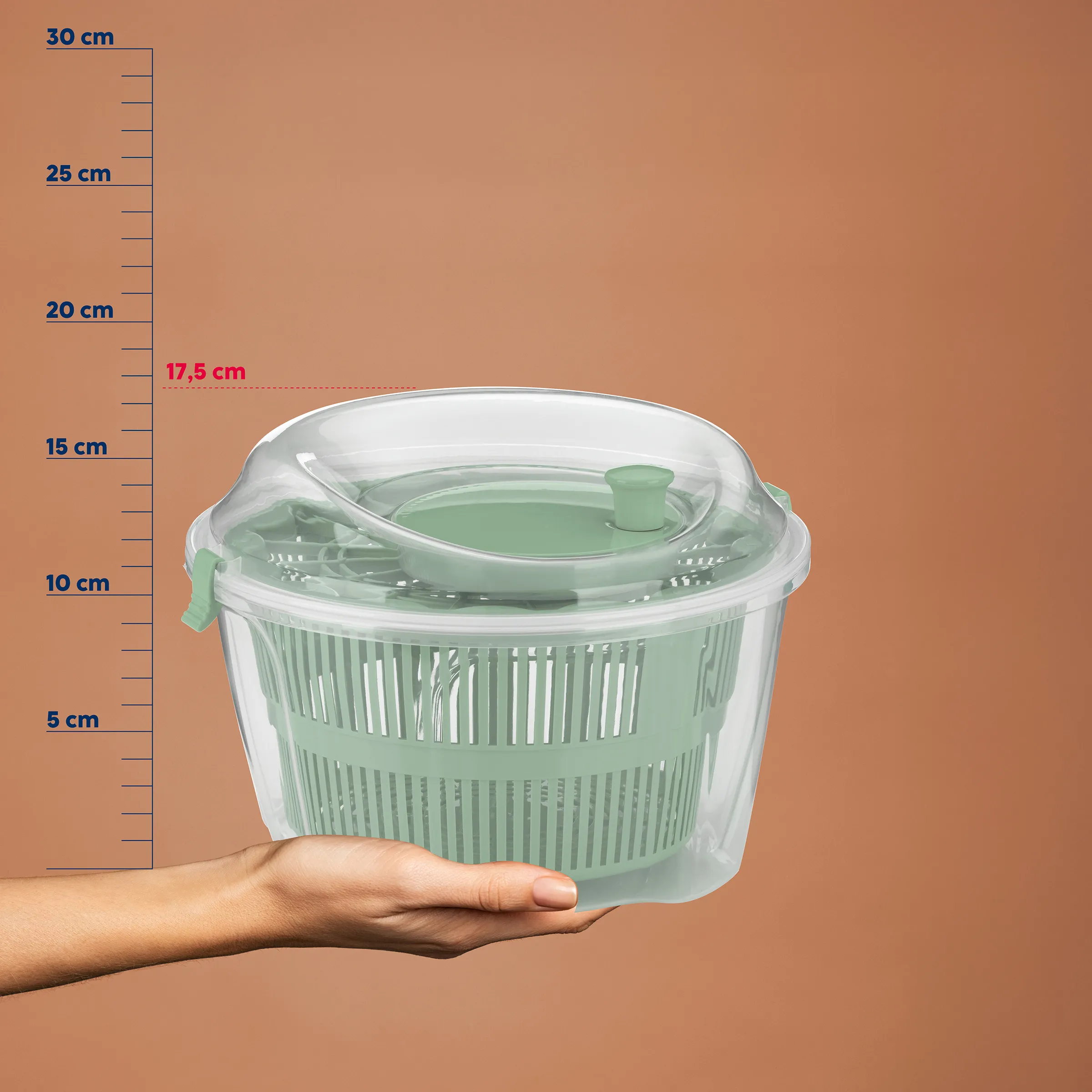 Salatschleuder mit Deckel und Größenangabe - Küchenhelfer 17,5 cm hoch Salatschleuder in Mint-Grün mit transparentem Deckel, gehalten von einer Hand vor Größenskala bis 30 cm