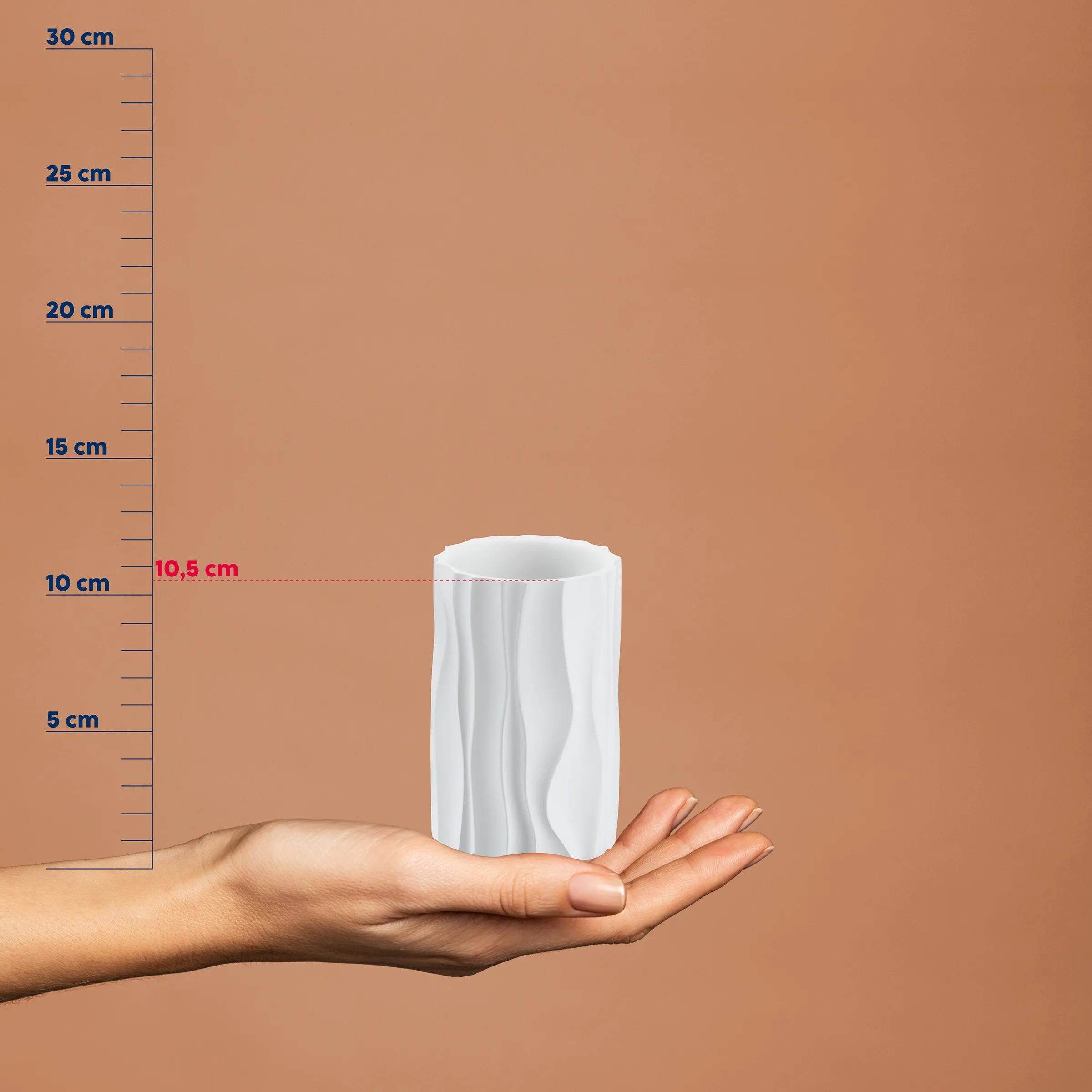 Weiße Vase mit gewelltem Design, 10,5 cm hoch, in Hand gehalten vor Maßstab