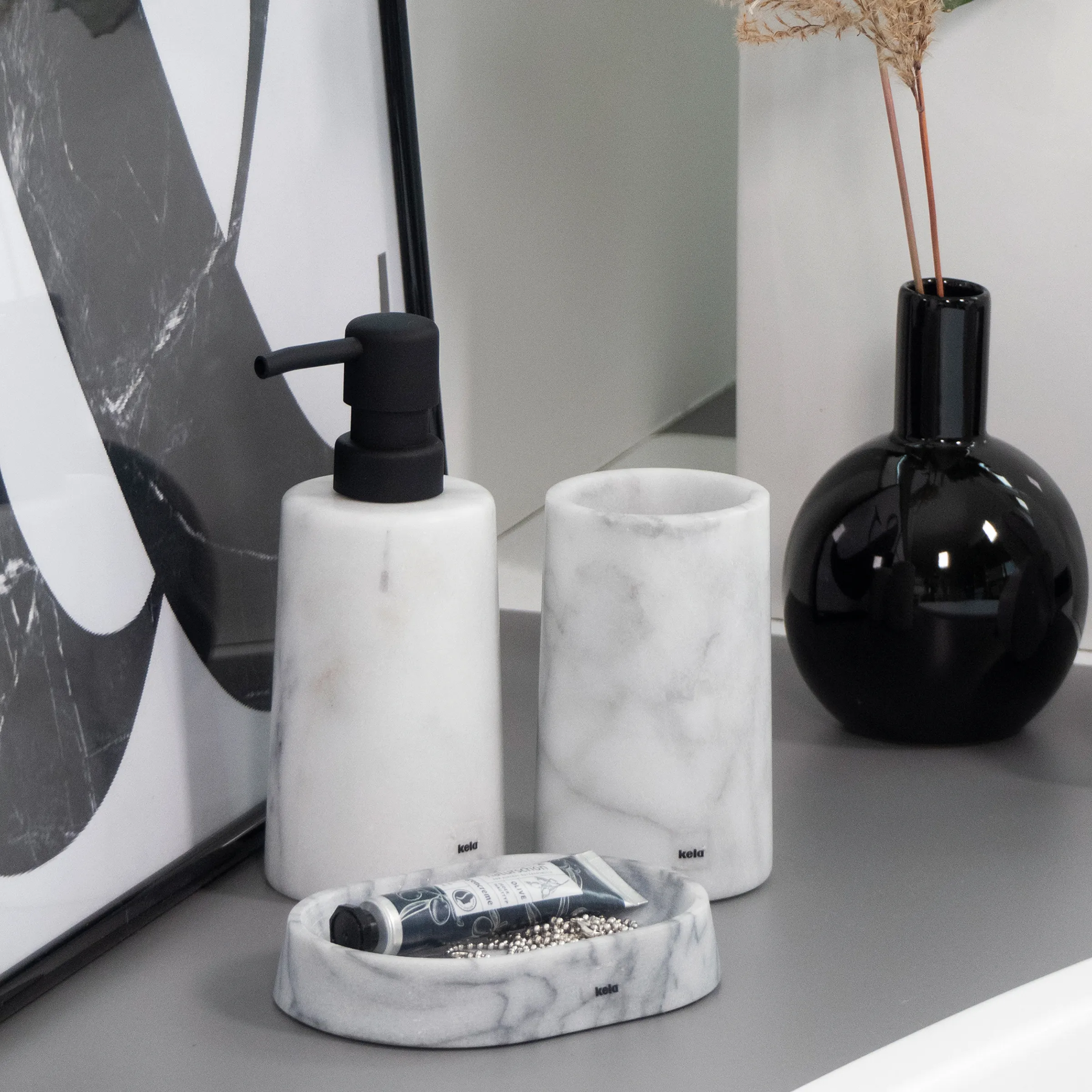 Modernes Marmor-Badezimmerset mit zwei Seifenspendern, Zahnbürstenhalter und schwarzer Vase mit getrockneten Blüten