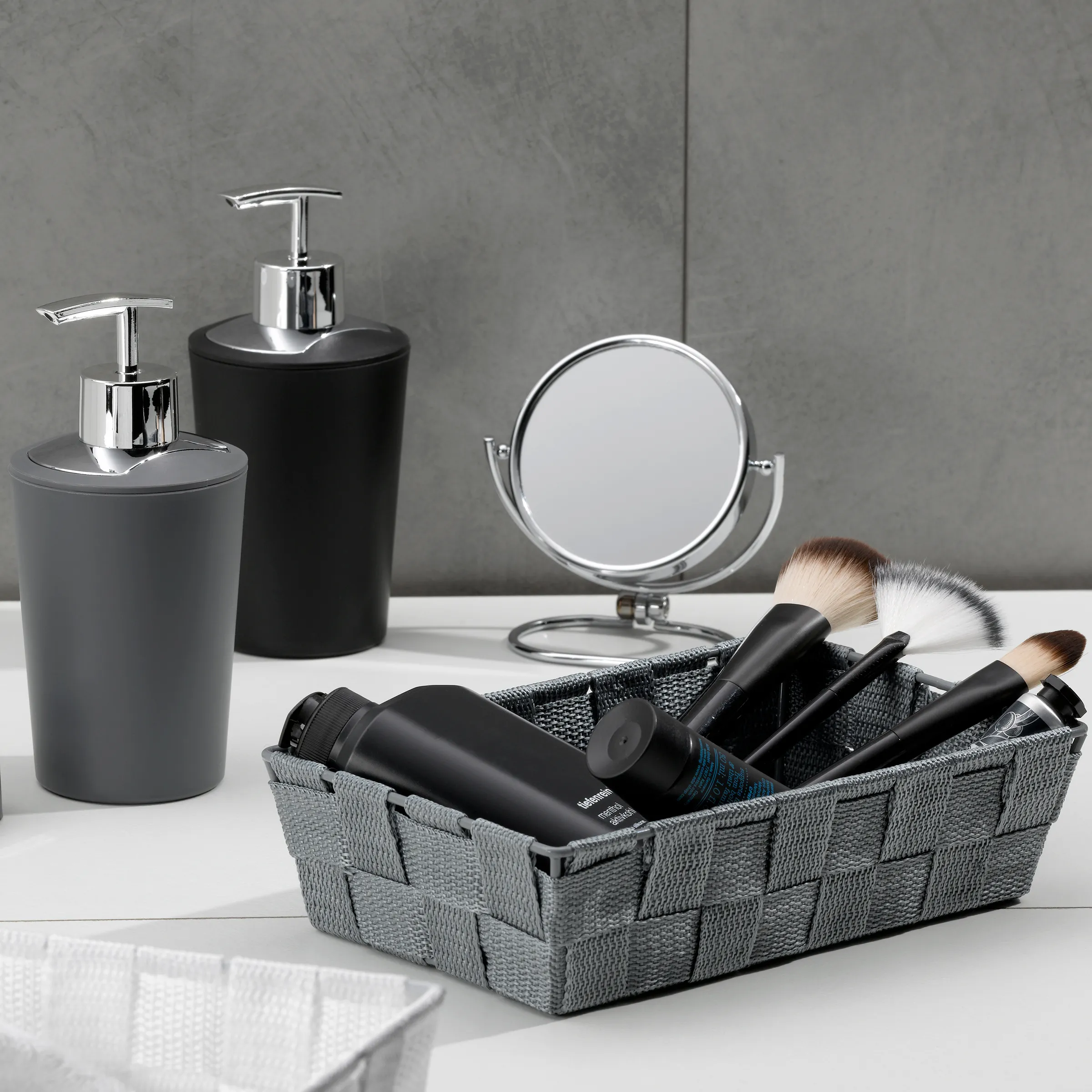 Badezimmer Accessoires Set - Seifenspender und Kosmetik-Organizer Badezimmer-Accessoires-Set mit grauem und schwarzem Seifenspender, Kosmetiktüchern, runder Spiegeln und Make-up-Pinseln in Korb