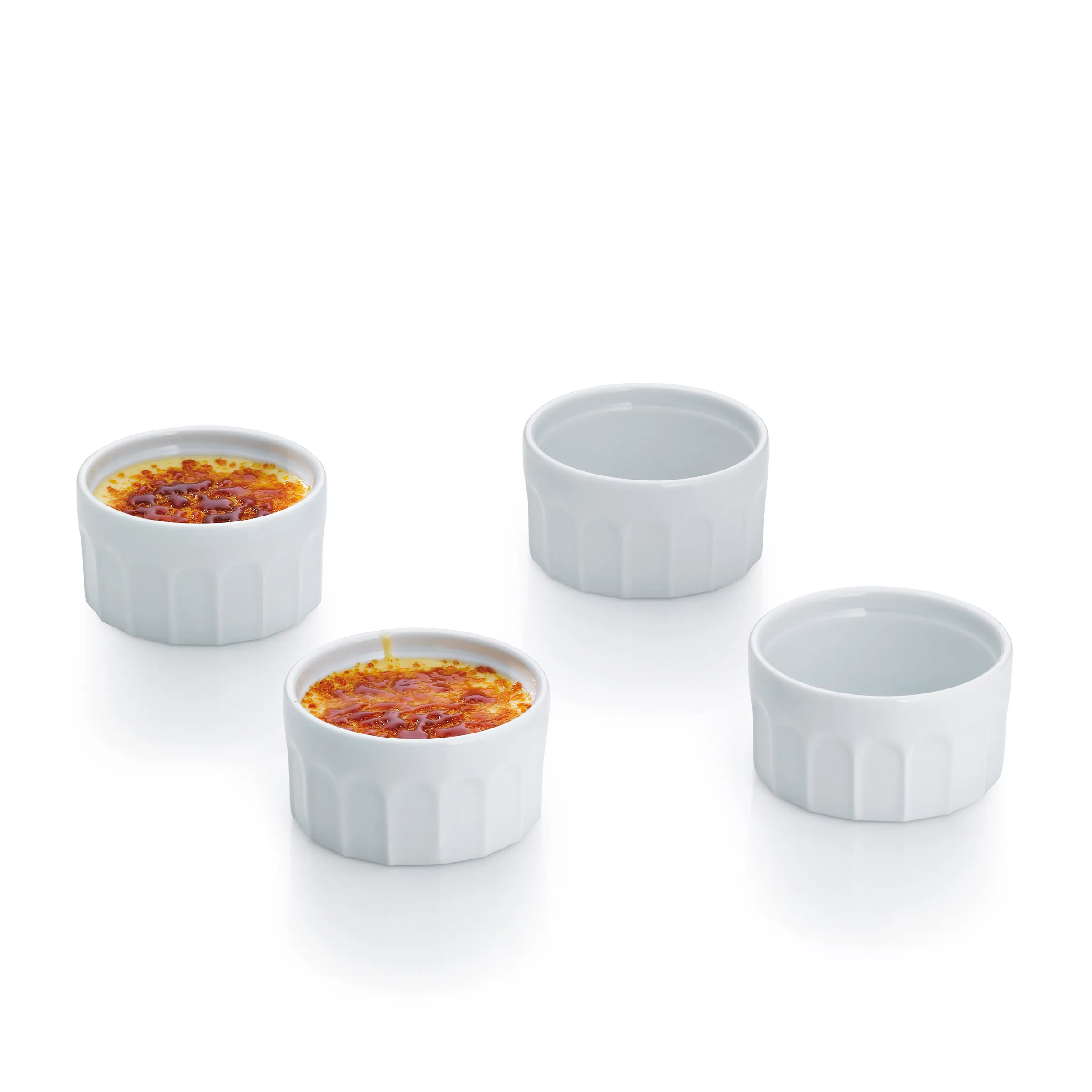 Crème-brûlée-Förmchen Set Porzellan - Dessertschalen mit gerilltem Design Vier weiße Crème-brûlée-Förmchen aus Porzellan, zwei mit karamellisierter Oberfläche, zwei leer
