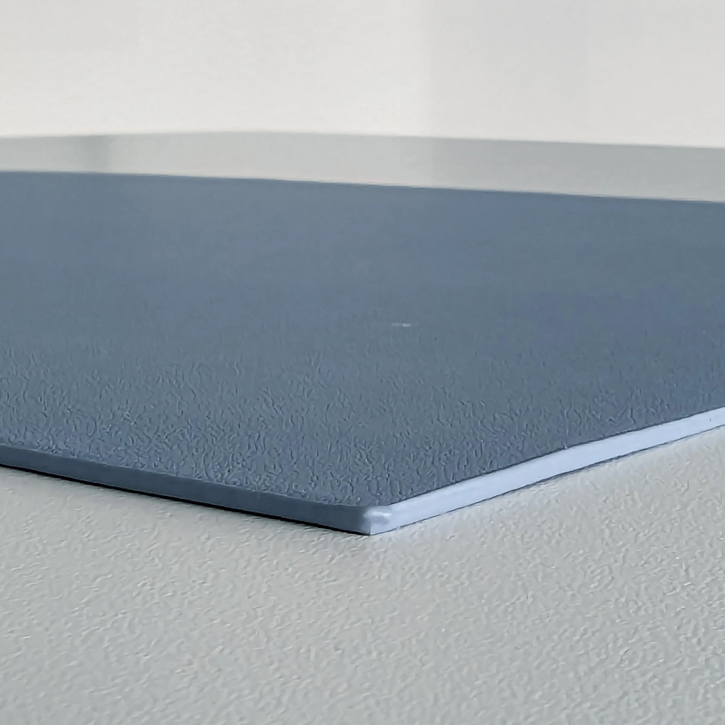 Strukturierte Gummimatte in Blaugrau - rutschfeste Bodenmatte mit Prägung Blaugraue strukturierte Gummimatte mit texturierter Oberfläche auf weißem Untergrund